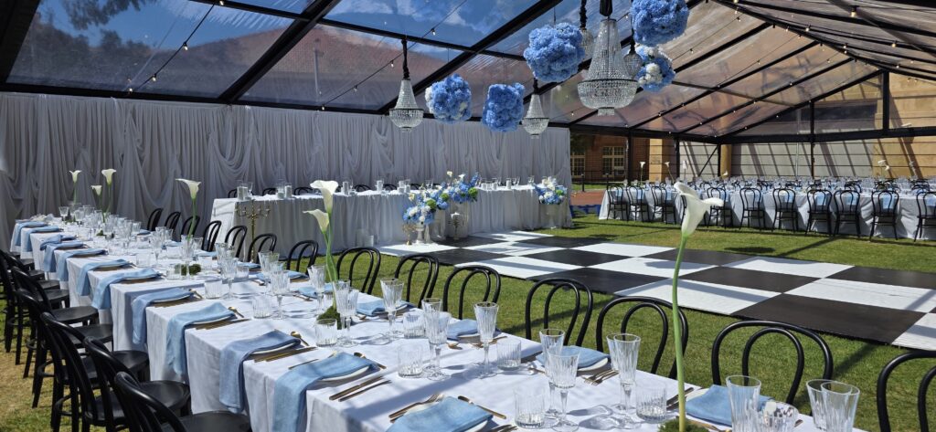 Sophisticated marquee wedding setup at SA Museum featuring black frame marquee, checkered dance floor, designer and furniture by Australian Hiring Company.
