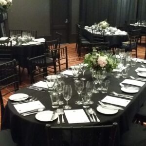 Oval dining table set for formal event in Adelaide marquee with chairs and décor